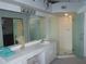 Bright bathroom featuring a spacious vanity, a large mirror, and a glass-enclosed walk-in shower at 402 Bouchelle Dr # 205, New Smyrna Beach, FL 32169