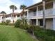 Charming condos with white railings, lush landscaping, and palm trees create a welcoming community atmosphere at 402 Bouchelle Dr # 205, New Smyrna Beach, FL 32169