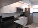 Efficient kitchen featuring white cabinetry, stainless steel appliances, and black countertops for meal preparation at 402 Bouchelle Dr # 205, New Smyrna Beach, FL 32169