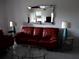 Comfortable living room featuring a red couch, mirrors, and neutral walls at 402 Bouchelle Dr # 205, New Smyrna Beach, FL 32169