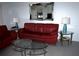 Cozy living room features a bright red sofa and modern glass tables at 402 Bouchelle Dr # 205, New Smyrna Beach, FL 32169