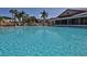 A large refreshing community pool with clear blue water and surrounding tropical landscaping on a sunny day at 402 Bouchelle Dr # 205, New Smyrna Beach, FL 32169