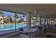 Relaxing poolside view with tables and chairs under a covered area, overlooking a sparkling community pool at 402 Bouchelle Dr # 205, New Smyrna Beach, FL 32169