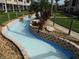 Scenic view of the community's lazy river water feature and lush landscaping at 402 Bouchelle Dr # 205, New Smyrna Beach, FL 32169