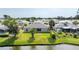 A beautiful backyard featuring a pond view, patio, and lush green lawn with tropical palm trees at 404 Central Mariners Dr, Edgewater, FL 32141