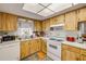 Efficient kitchen featuring light wood cabinetry, a window view, and standard appliances at 412 Banana Cay Dr # A, South Daytona, FL 32119