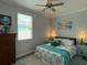 Comfortable bedroom features a ceiling fan, windows and two end tables at 415 Jessamine Ave, New Smyrna Beach, FL 32169