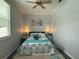Comfortable bedroom features a ceiling fan, windows and end tables at 415 Jessamine Ave, New Smyrna Beach, FL 32169