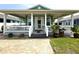 Charming home featuring a spacious covered front porch with white railings and decorative potted plants at 415 Jessamine Ave, New Smyrna Beach, FL 32169