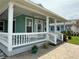 Inviting front porch with white railings and columns, offering a pleasant outdoor space at 415 Jessamine Ave, New Smyrna Beach, FL 32169
