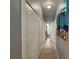 Hallway with closet and tiled flooring, leading to the bathroom at the end at 415 Jessamine Ave, New Smyrna Beach, FL 32169