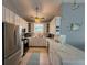 Stylish kitchen boasting white cabinetry, stainless steel appliances, and a marble countertop bar at 415 Jessamine Ave, New Smyrna Beach, FL 32169