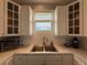Kitchen sink with stainless steel appliances, white cabinets and view through the window at 415 Jessamine Ave, New Smyrna Beach, FL 32169