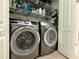 Laundry room featuring modern front-loading washer and dryer with storage shelves at 415 Jessamine Ave, New Smyrna Beach, FL 32169