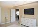Bedroom showcases a TV, dresser, and doorway to another room, providing functionality and connectivity at 426 Bouchelle Dr # 401, New Smyrna Beach, FL 32169