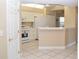 Open kitchen with white appliances, cabinetry, and tile flooring at 426 Bouchelle Dr # 401, New Smyrna Beach, FL 32169