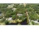 A tranquil aerial view of a home with abundant trees and bordered by a beautiful pond at 4580 Lake James Cir, Edgewater, FL 32141