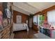 Bedroom featuring wood walls, white curtains, a brick fireplace, and a pink desk chair at 4580 Lake James Cir, Edgewater, FL 32141