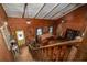 Open living room with wood walls, exposed ceiling beams, and a bright yellow front door at 4580 Lake James Cir, Edgewater, FL 32141