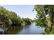 Picturesque waterfront view with lush trees bordering the tranquil water at 4580 Lake James Cir, Edgewater, FL 32141