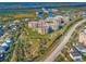 Beautiful aerial view of a condo complex with a golf course and landscaping by the water and highway at 4670 Links Village Dr # D206, Ponce Inlet, FL 32127