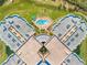 Aerial view showing the property's layout, surrounding golf course, and sparkling pool and community area at 4670 Links Village Dr # D206, Ponce Inlet, FL 32127