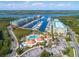 Aerial view featuring a marina with boats, a pool, and community buildings at a condo complex at 4670 Links Village Dr # D206, Ponce Inlet, FL 32127