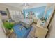 Bedroom with a bed and blue accent wall with water-themed decor at 4670 Links Village Dr # D206, Ponce Inlet, FL 32127
