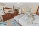 Bedroom with a four poster bed, wood flooring, and view into the ensuite bath at 4670 Links Village Dr # D206, Ponce Inlet, FL 32127