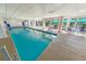 Well-lit indoor pool area with comfortable seating, accessible by stairs and ladders, for recreational swimming at 4670 Links Village Dr # D206, Ponce Inlet, FL 32127