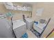 Practical laundry room with washer, dryer, and utility sink, complemented by ample storage shelving at 4670 Links Village Dr # D206, Ponce Inlet, FL 32127