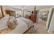 Comfortable main bedroom with a four-poster bed, fan, and view to the outside at 4670 Links Village Dr # D206, Ponce Inlet, FL 32127