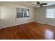 Bright bedroom with hardwood floors, two windows, and ceiling fan, offering a comfortable living space at 5018 Riverside Dr, Port Orange, FL 32127