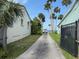 Long driveway leading to the water, lined with palm trees and green spaces at 5018 Riverside Dr, Port Orange, FL 32127
