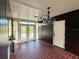 Charming entryway featuring red brick flooring, wood paneling, and a beautiful blue chandelier at 5018 Riverside Dr, Port Orange, FL 32127