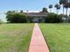 Expansive front lawn leads to a cozy single-story home under a sunny sky, surrounded by mature greenery at 5018 Riverside Dr, Port Orange, FL 32127