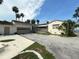 Exterior view of a home with a tile roof, large garage, and spacious paved driveway at 5018 Riverside Dr, Port Orange, FL 32127