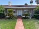 Charming single-story home featuring mature landscaping, a red-tiled roof, and inviting curb appeal at 5018 Riverside Dr, Port Orange, FL 32127