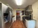 Modern kitchen with stainless steel appliances, tile floors, and an open view into the sunroom at 5018 Riverside Dr, Port Orange, FL 32127