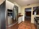 Kitchen with stainless steel refrigerator, cooktop, tile flooring, white cabinetry, and natural lighting at 5018 Riverside Dr, Port Orange, FL 32127