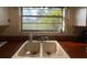 Kitchen featuring a double basin sink and a window with lush greenery views at 5018 Riverside Dr, Port Orange, FL 32127