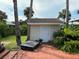 Small outbuilding with a tile roof surrounded by palm trees and lush vegetation at 5018 Riverside Dr, Port Orange, FL 32127