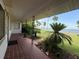 Spacious front porch with brick flooring, offering a beautiful view of the water and tropical greenery at 5018 Riverside Dr, Port Orange, FL 32127
