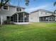 Large, well-maintained backyard featuring a screened-in patio, and lush lawn at 567 Mount Olympus Blvd, New Smyrna Beach, FL 32168