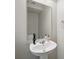 Contemporary half-bath features a pedestal sink, large mirror, and stylish fixtures at 567 Mount Olympus Blvd, New Smyrna Beach, FL 32168