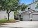Charming townhome with a two-car garage, green shrubs, and a well-manicured front lawn at 567 Mount Olympus Blvd, New Smyrna Beach, FL 32168