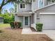 Inviting front entrance with a well-kept lawn, decorative bushes, and neutral paint at 567 Mount Olympus Blvd, New Smyrna Beach, FL 32168