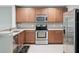 An updated kitchen featuring stainless steel appliances, light countertops, and wood cabinets at 567 Mount Olympus Blvd, New Smyrna Beach, FL 32168