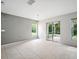 Neutral living room features tile flooring, a contemporary light fixture, and sliding doors to an outdoor space at 567 Mount Olympus Blvd, New Smyrna Beach, FL 32168