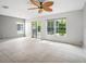Bright living room with tile floors, ceiling fan, and access to the outdoors through sliding glass doors at 567 Mount Olympus Blvd, New Smyrna Beach, FL 32168